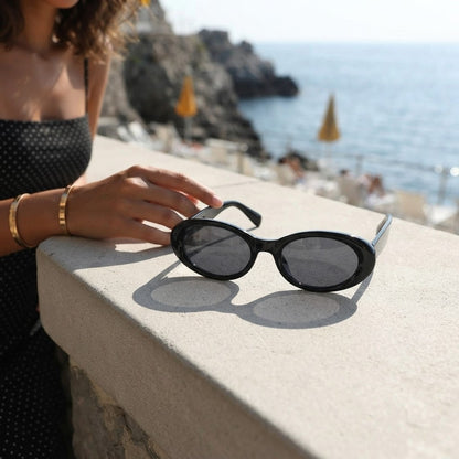 Black oval sunglasses with UV protection from Redemption by Ashley North, featuring a sleek, rounded design and one-size fit.