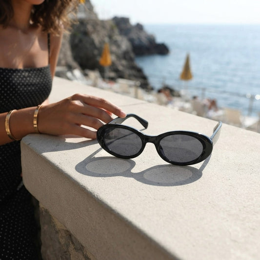 Black oval sunglasses with UV protection from Redemption by Ashley North, featuring a sleek, rounded design and one-size fit.