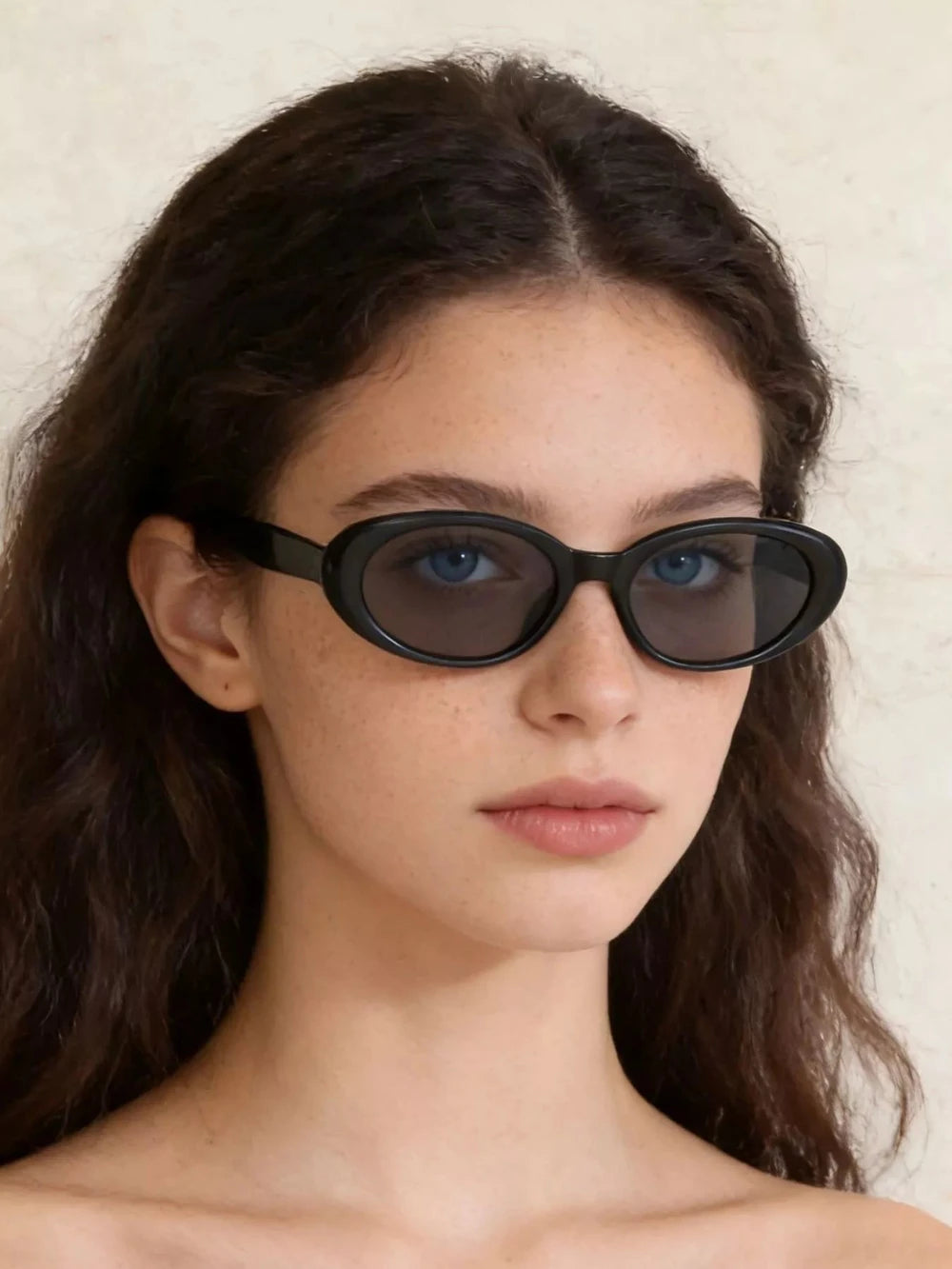 Black oval sunglasses with UV protection from Redemption by Ashley North, featuring a sleek, modern design.
