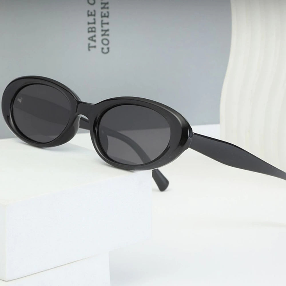Black oval sunglasses with UV protection from Redemption by Ashley North, featuring a sleek, modern design.