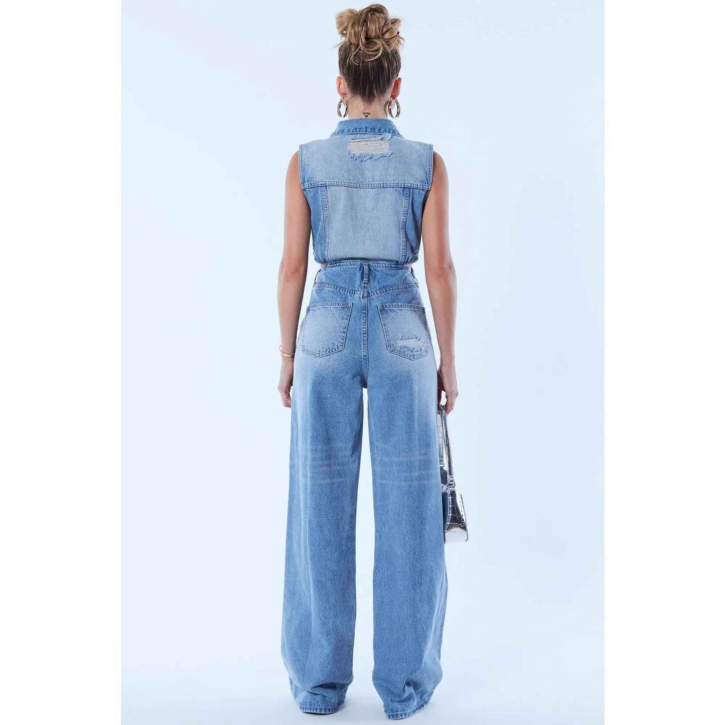 Light wash denim Baylin jumpsuit by Redemption By Ashley North, showing a fitted sleeveless style with front pockets.