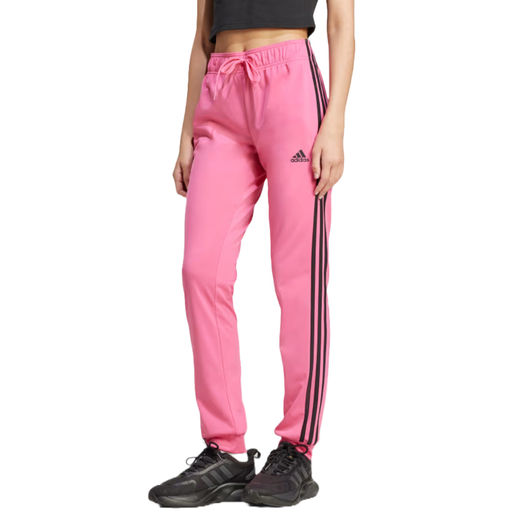 Runnwalk adidas women's Primegreen Essentials warm-up slim tapered track pants in Pulse Magenta with 3-stripes and tapered fit.