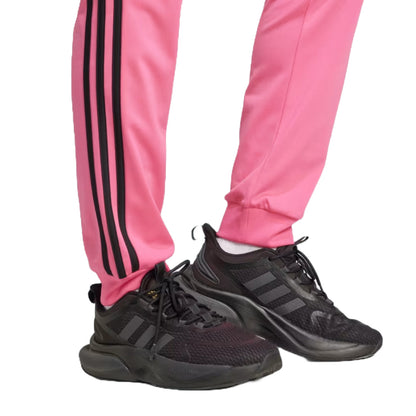 Runnwalk adidas women's Primegreen Essentials slim tapered track pants in pulse magenta with 3-stripes and tapered fit.
