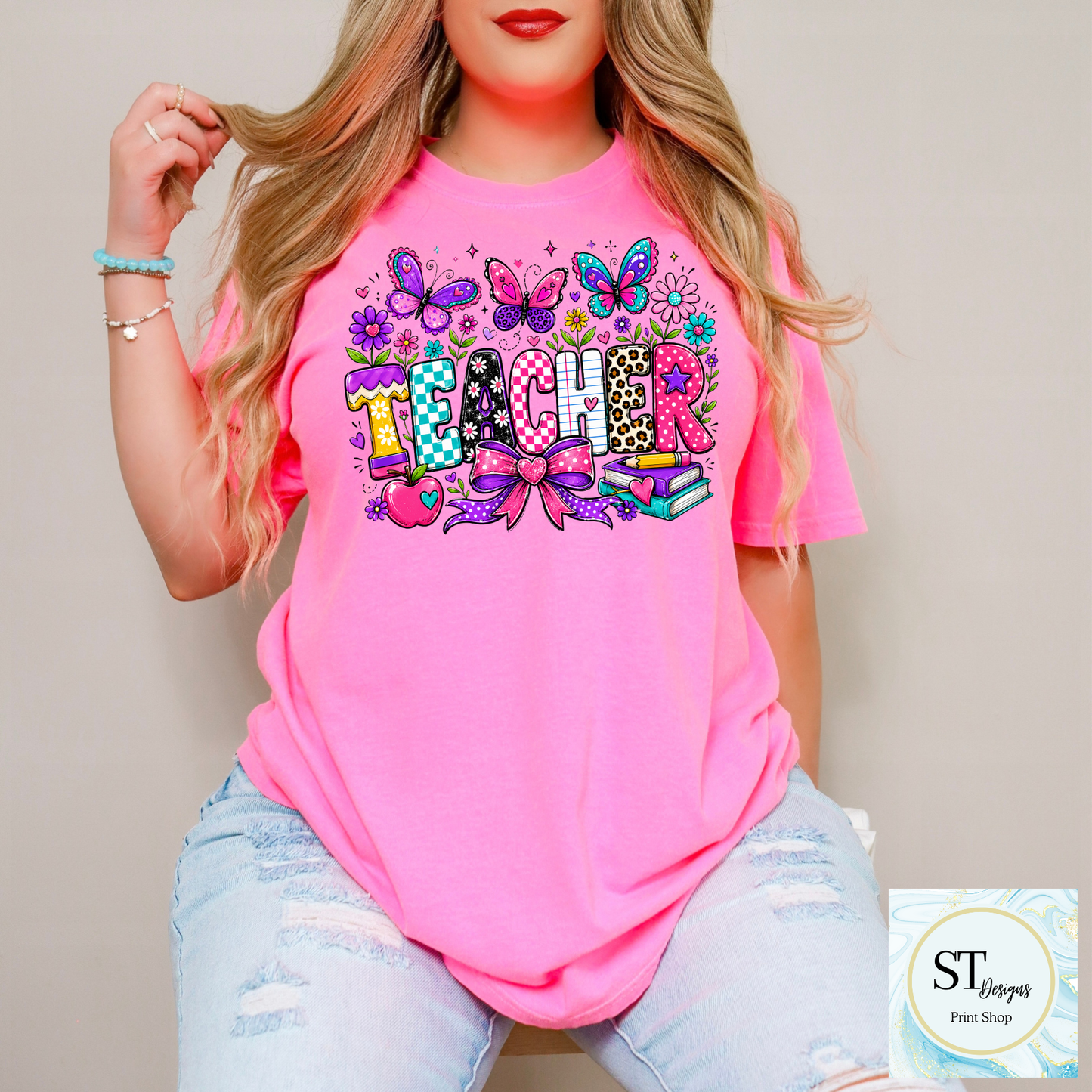 Colorful teacher graphic crewneck sweatshirt in sand color, featuring vibrant educational-themed design from ST Designs Store.