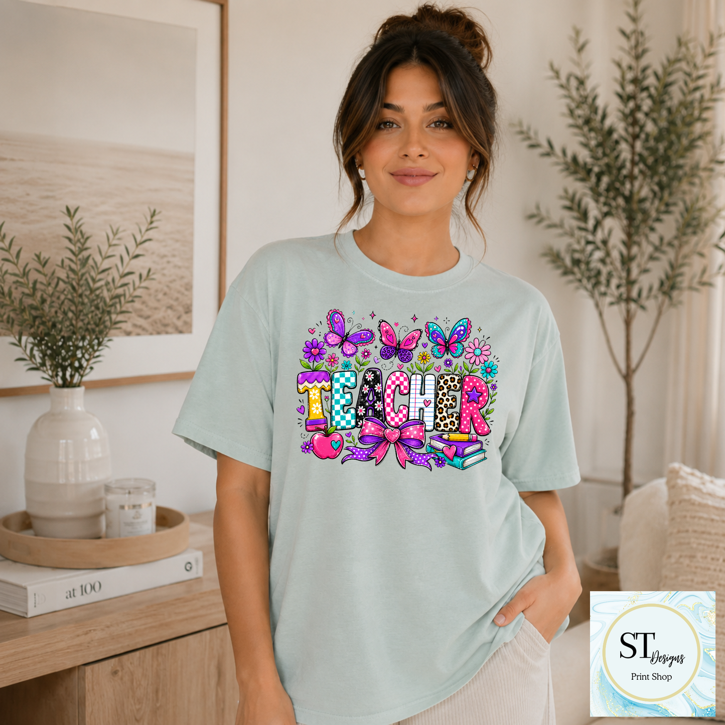 Colorful teacher graphic crewneck sweatshirt in sand color with vibrant educational-themed design by ST Designs Store.