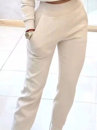 Casual chic cropped sweatshirt and jogger set by Trendsi, featuring a relaxed fit and comfortable fabric in neutral tones.