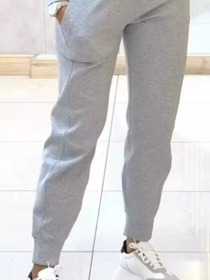 Casual Chic Cropped Sweatshirt and Jogger Set by Trendsi, featuring a cozy cropped sweatshirt and matching joggers in a stylish casual look.