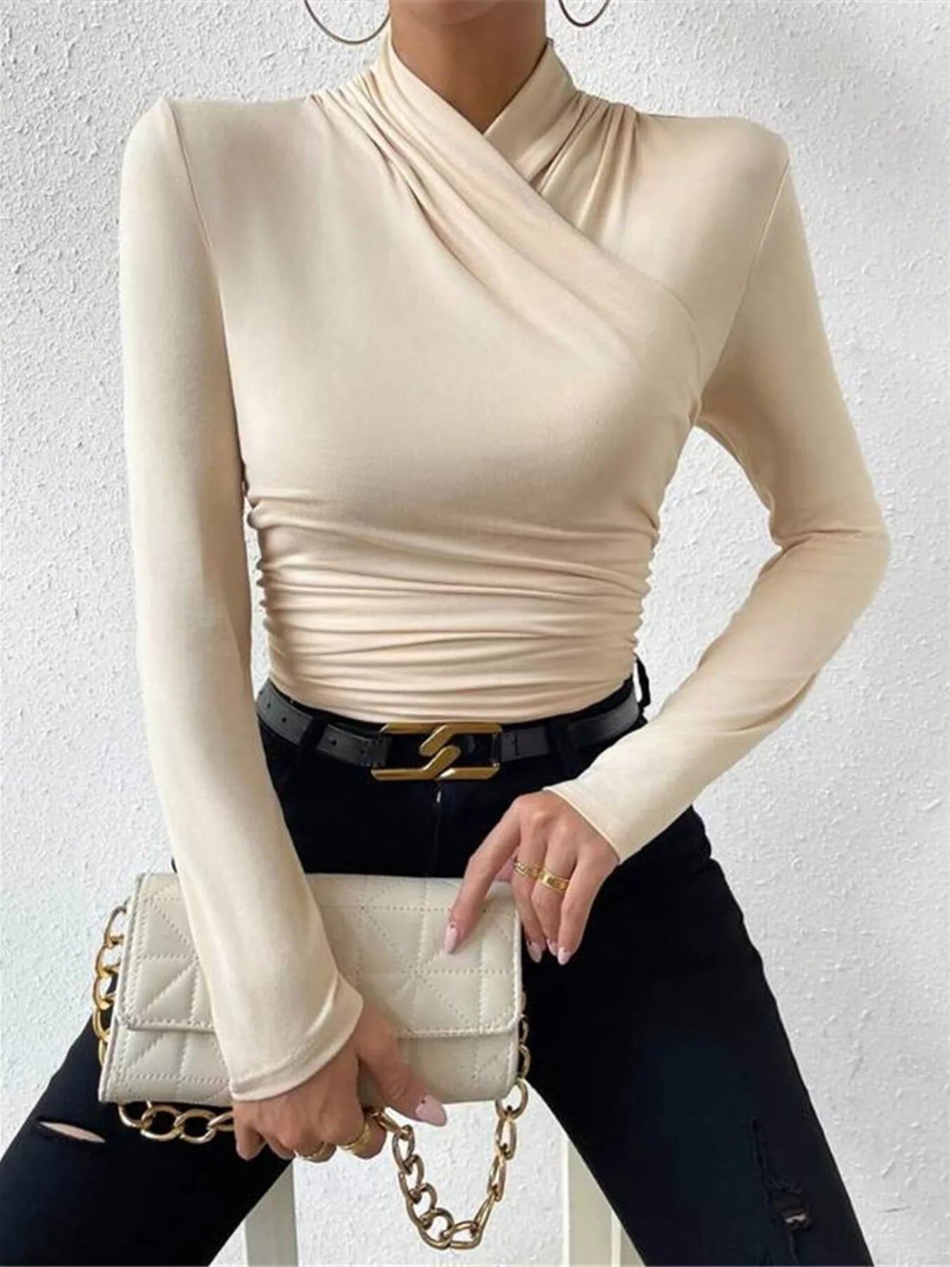 Black ruched long sleeve slim fit top by Trendsi, showing close-up of fitted fabric and ruched detailing on the sleeves.