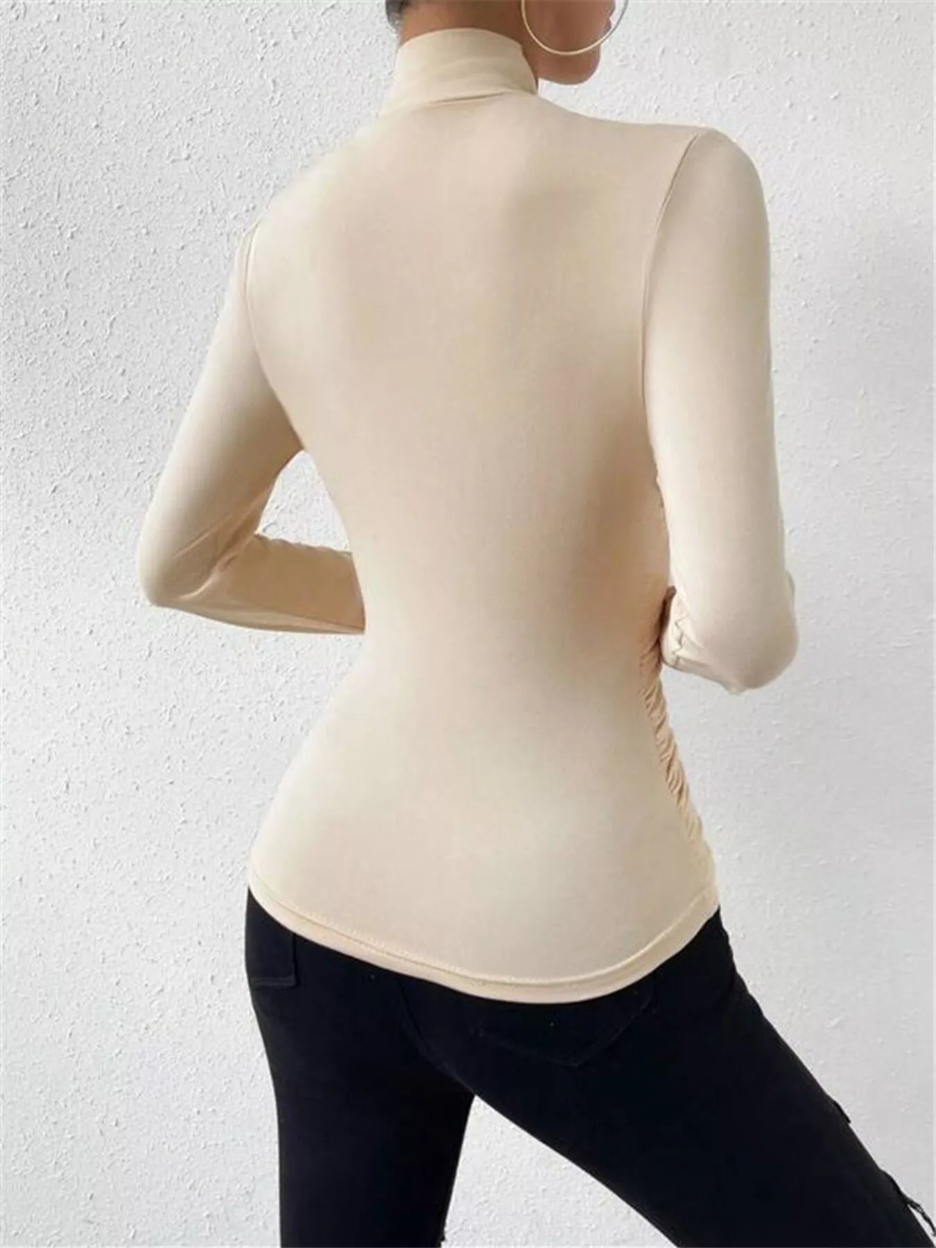 Black ruched long sleeve slim fit top from Trendsi, featuring gathered fabric details and a flattering fitted silhouette.