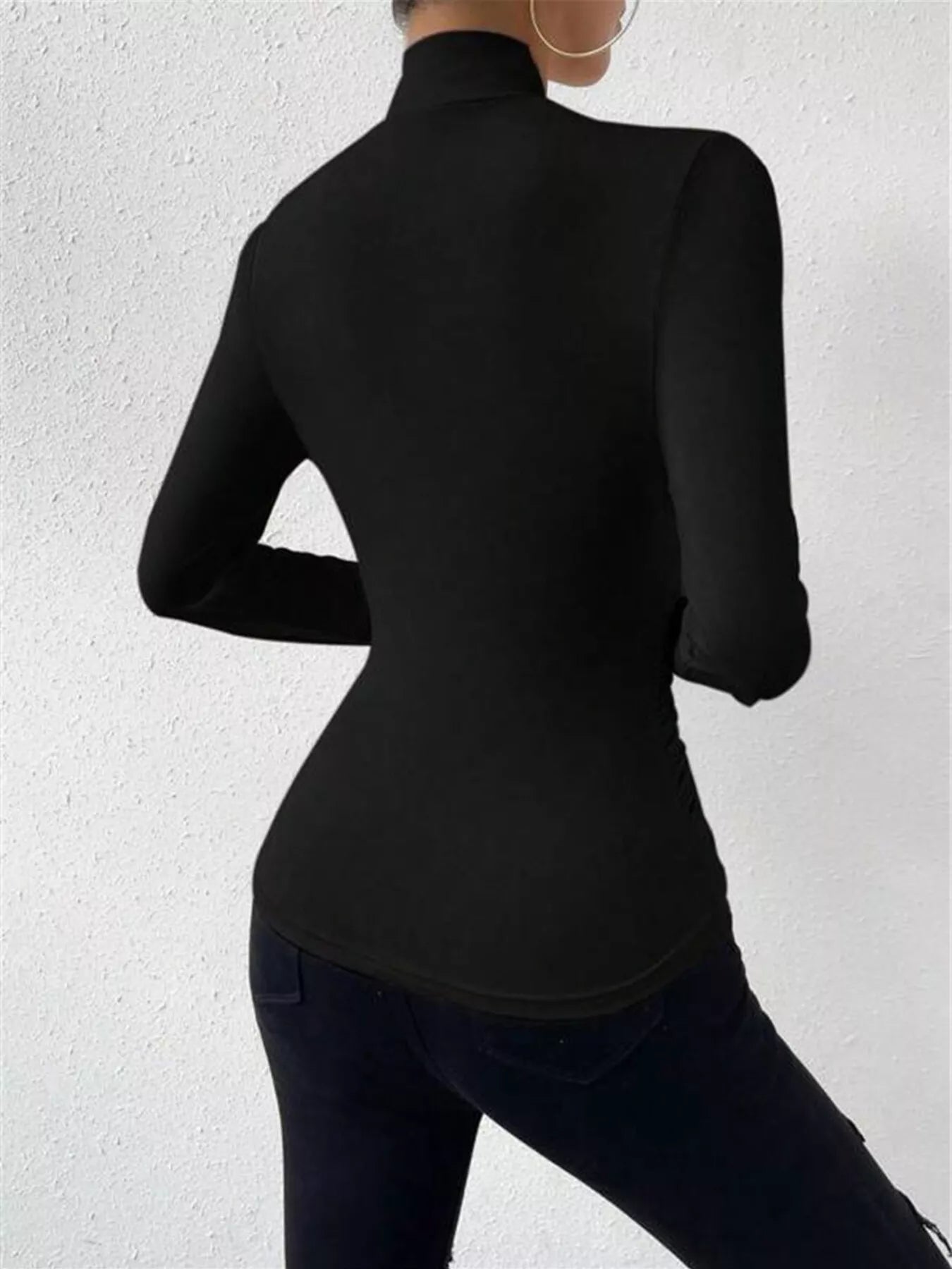 Ruched long sleeve slim fit top by Trendsi featuring a fitted design and ruched detailing, shown in a stylish black fabric.