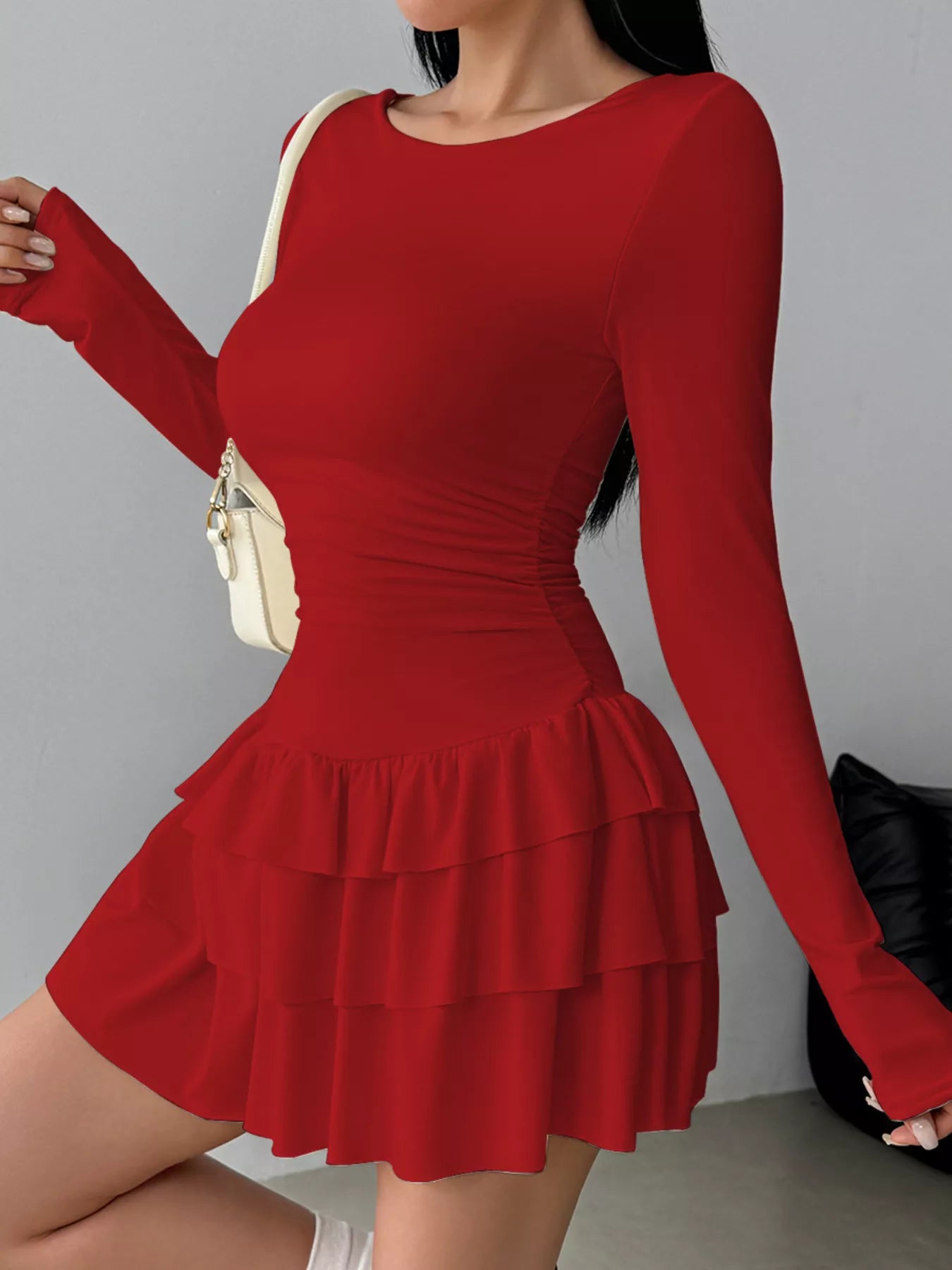Ruched long sleeve layered ruffle mini dress by Trendsi, showcasing the textured fabric and stylish design details.