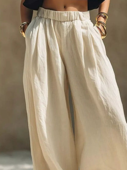 Beige plus size wide leg pants with full elastic waistband from Trendsi, featuring a relaxed fit and flowy fabric.