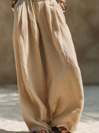 Plus size beige wide leg pants with elastic waistband from Trendsi, full-length, comfortable, and flowy for a relaxed fit.