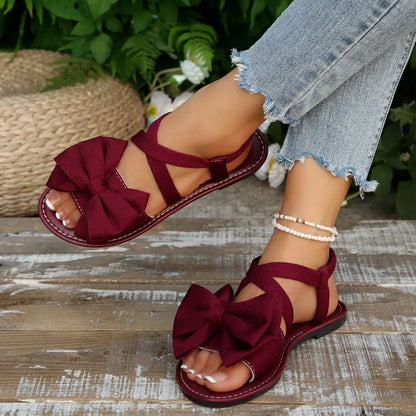 Black bow-embellished flat sandals from Trendsi with a stylish, comfortable design and decorative bows on the straps.