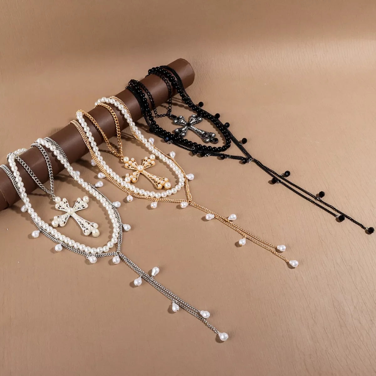 Three-piece set of pearl cross pendant necklaces by Trendsi featuring elegant cross and pearl designs on gold-tone chains.