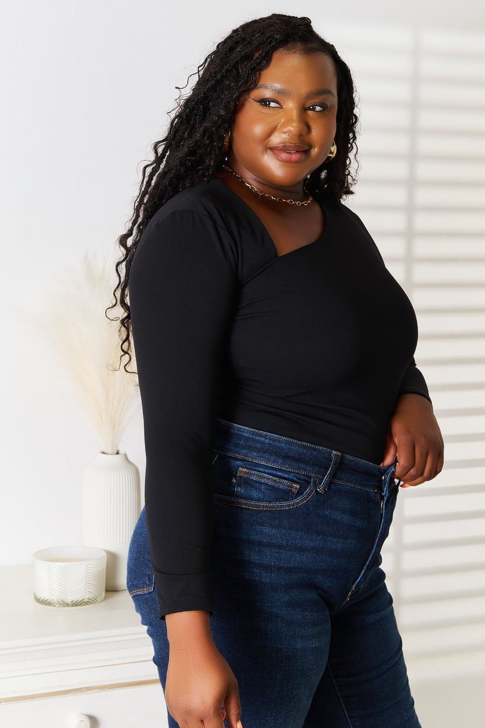 Black Basic Bae asymmetrical neck long sleeve top from Trendsi, featuring a stylish asymmetrical neckline and fitted long sleeves.