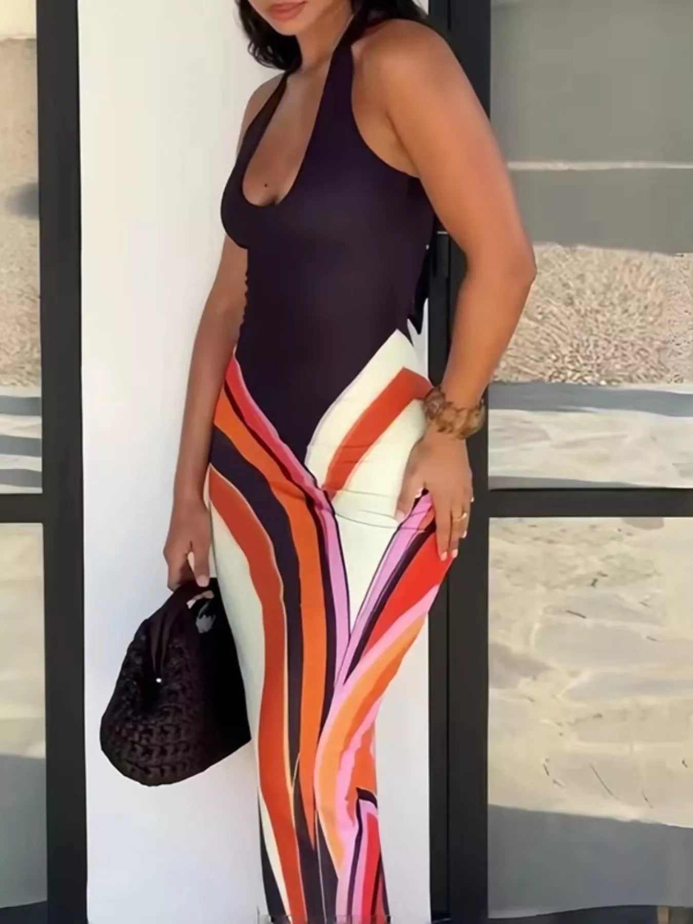 Black halter neck maxi dress with abstract print from Trendsi, featuring a flowing silhouette and stylish design.