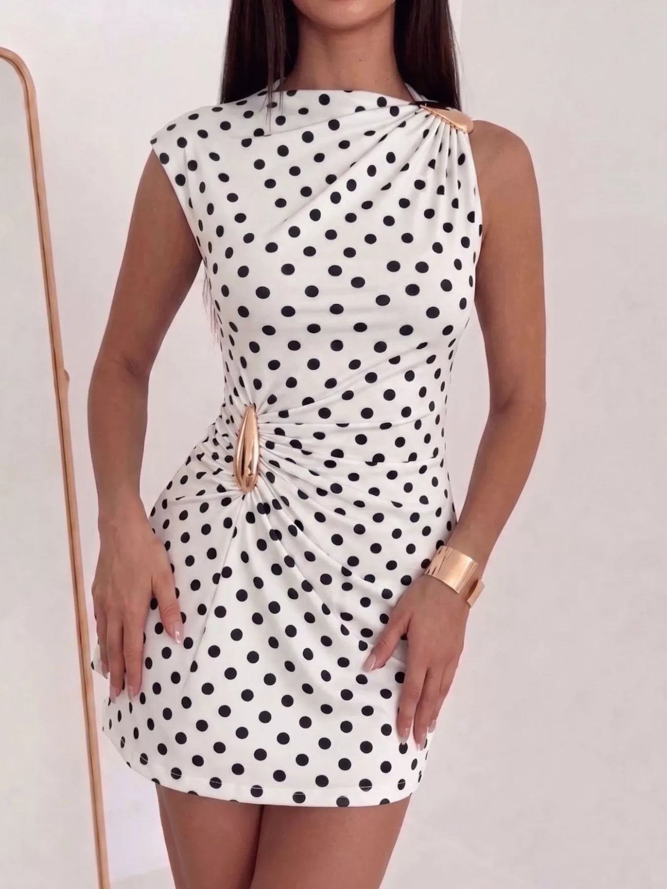 Sleeveless ruched asymmetrical mini dress by Trendsi, featuring a fitted silhouette and stylish design, shown in black fabric.