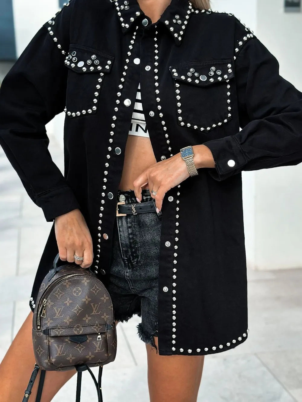 Black studded snap-down long sleeve denim shacket from Trendsi, featuring a classic collar and button closure with studded details.