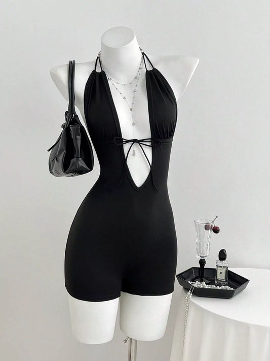 Black tied front halter neck romper by Trendsi, featuring a stylish halter design and fitted silhouette for a trendy summer look.