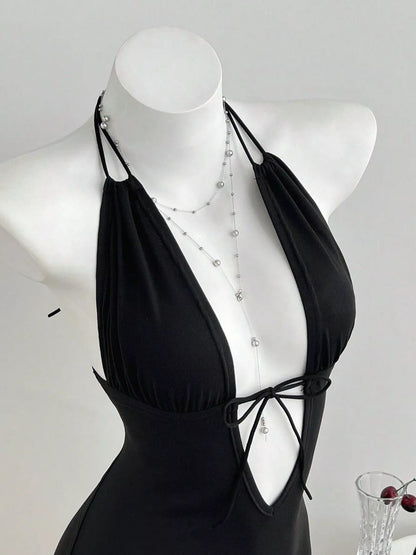 Black tied front halter neck romper by Trendsi, featuring a stylish design with a fitted waist and sleeveless silhouette.