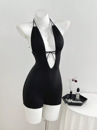 Black tied front halter neck romper by Trendsi, featuring a sleeveless design and stylish front tie detail.