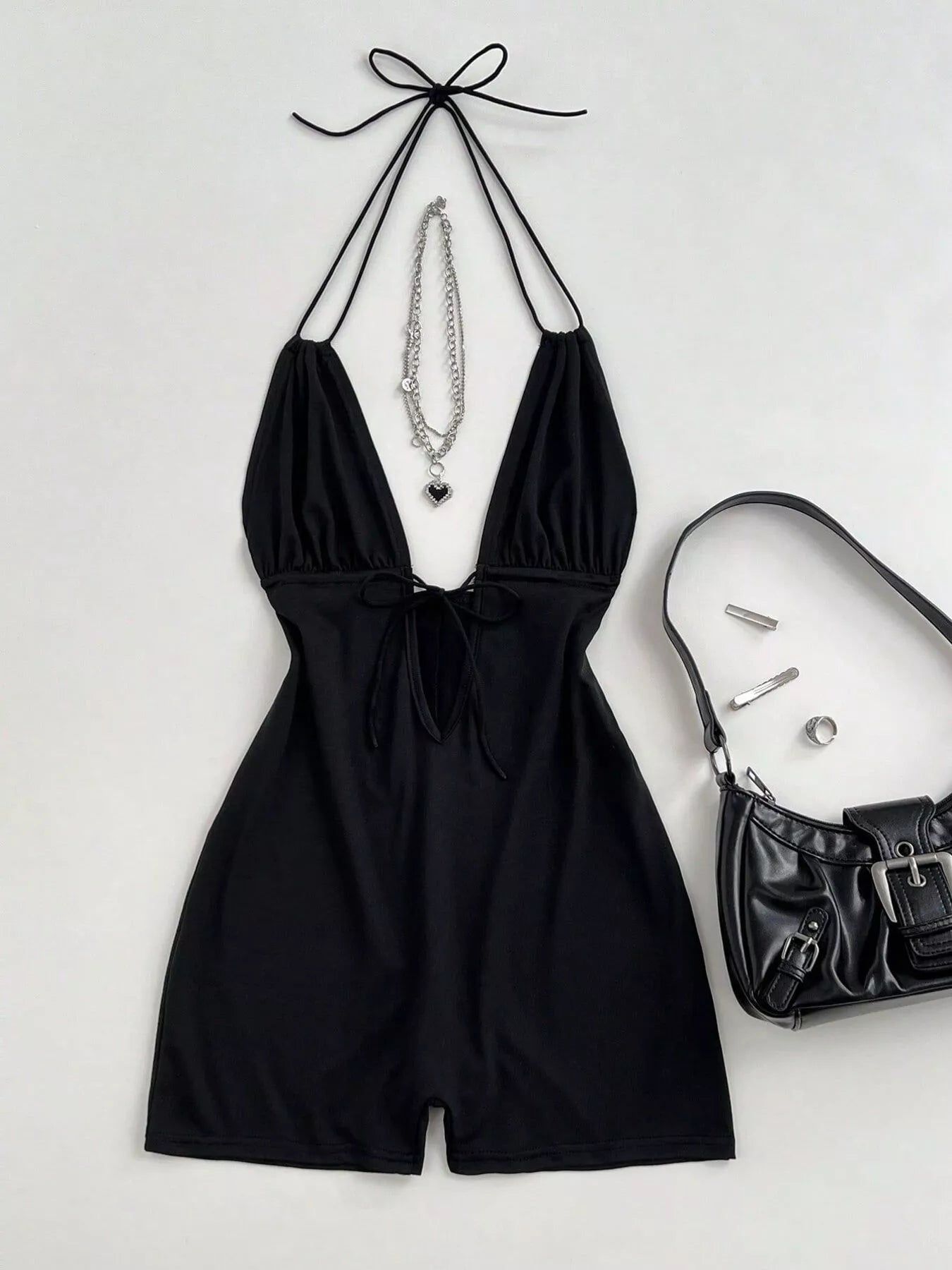Black tied front halter neck romper by Trendsi, featuring a stylish halter design and comfortable fit, perfect for summer wear.