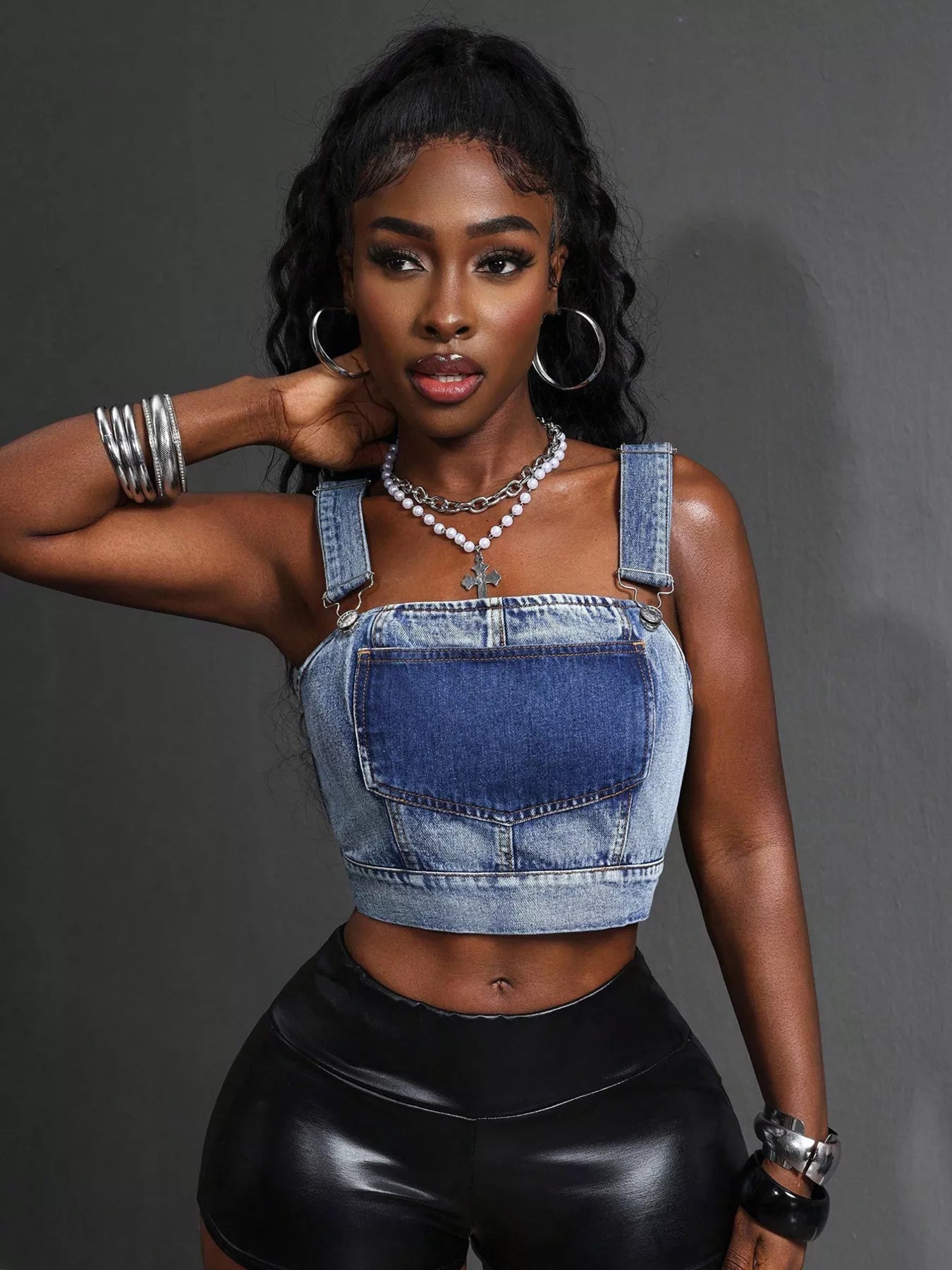 Blue cropped denim top with adjustable straps, featuring a trendy fit and classic denim texture for stylish casual wear.