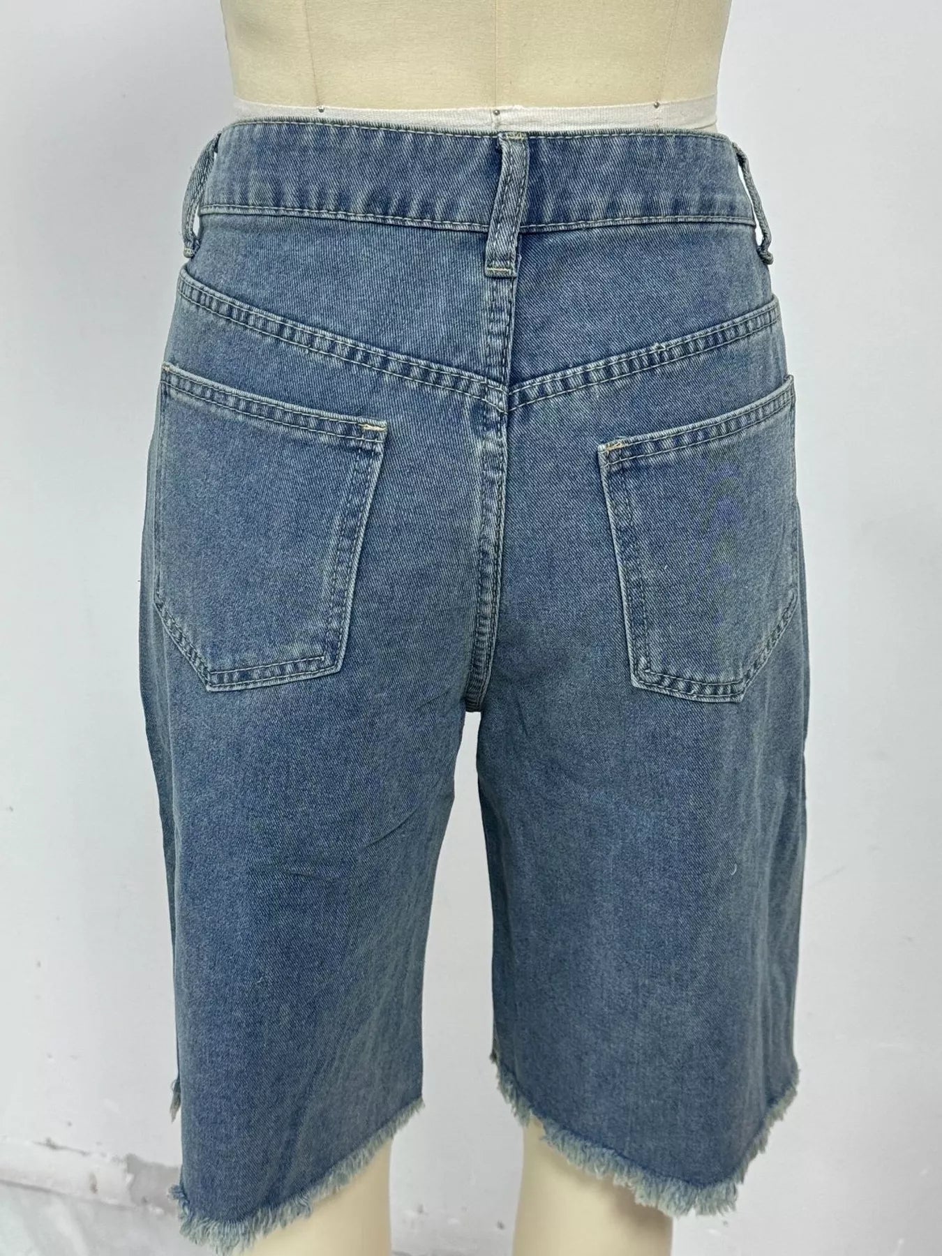 Blue frayed hem relaxed fit denim shorts by Trendsi, showcasing casual style and distressed denim fabric.
