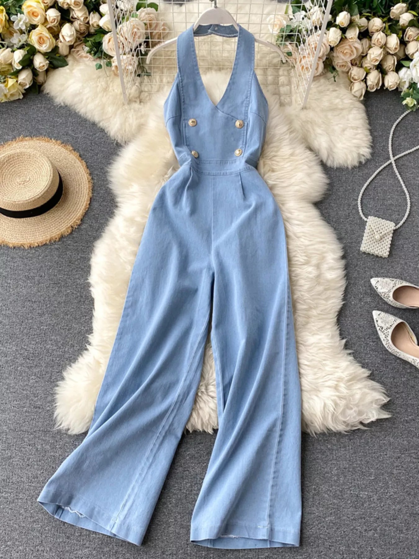 Halter neck wide leg denim jumpsuit by Trendsi featuring a fitted bodice and flowing wide leg pants for a stylish, casual look.