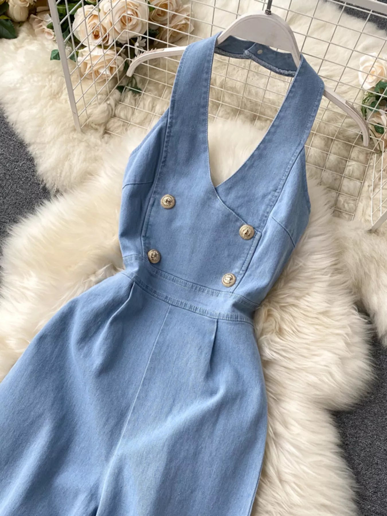 Halter neck wide-leg denim jumpsuit by Trendsi featuring a fitted bodice and relaxed wide-leg pants, front view.