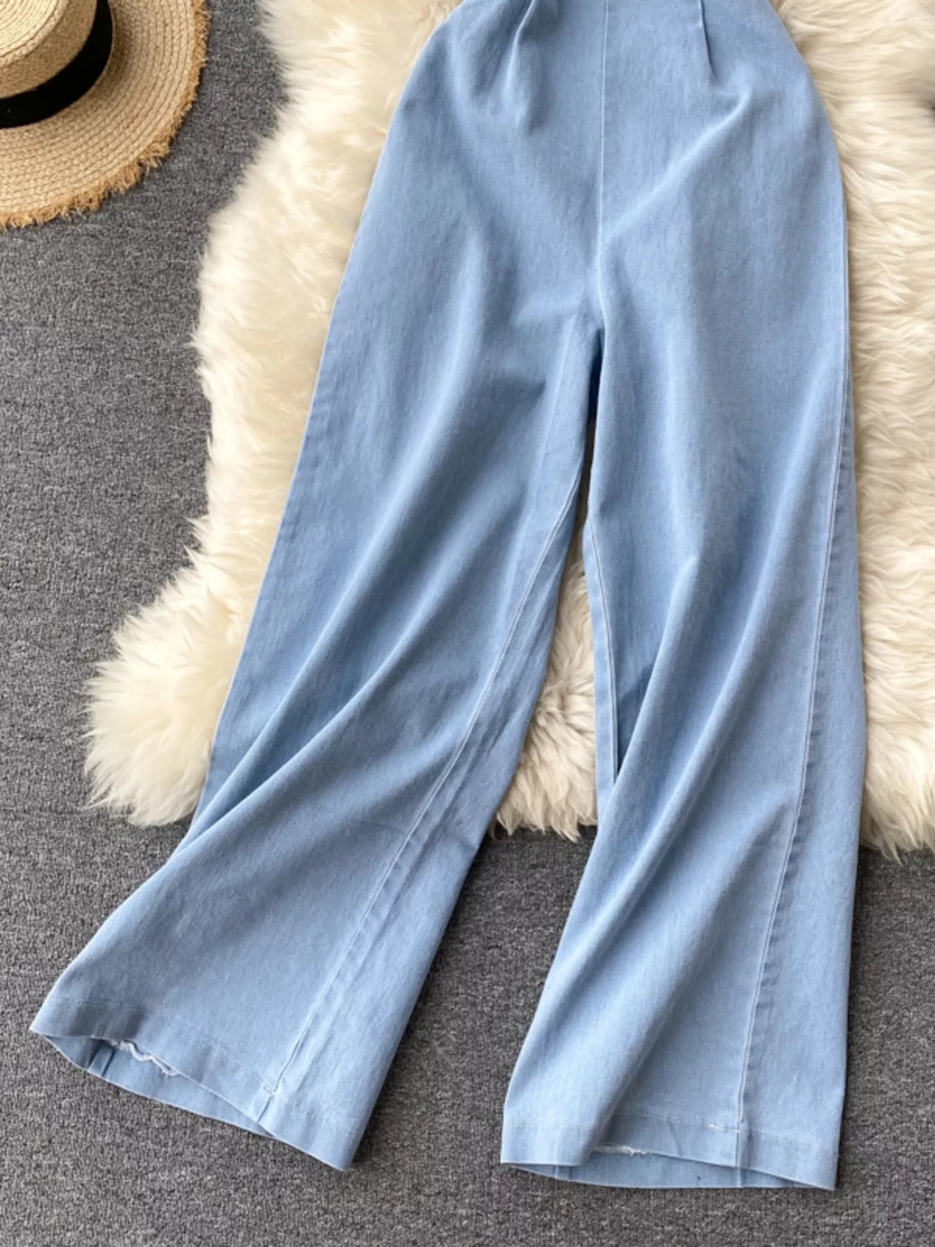 Halter neck wide-leg denim jumpsuit by Trendsi featuring a fitted bodice and flowing pant legs, perfect for casual or stylish outfits.
