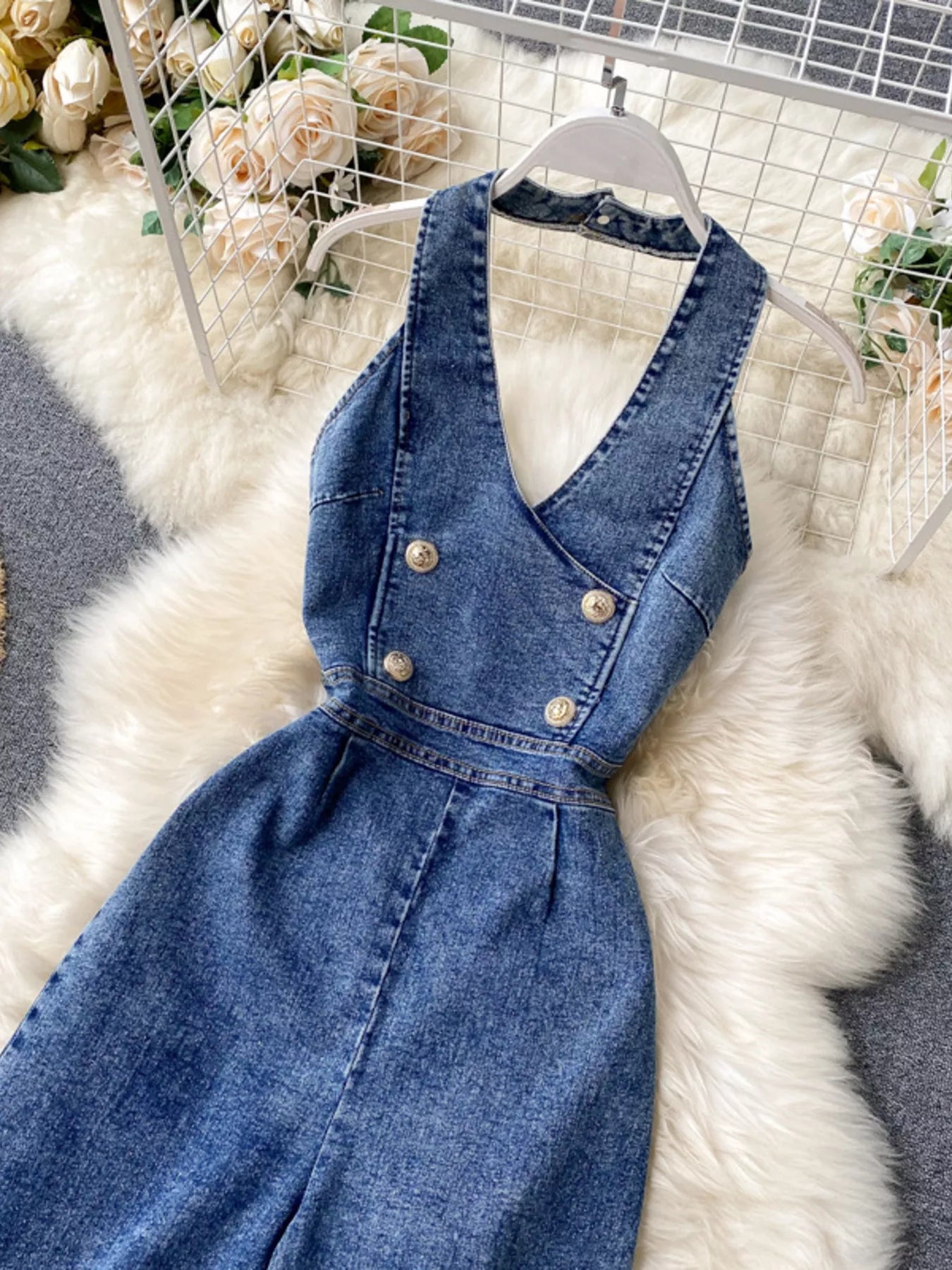 Halter neck wide-leg denim jumpsuit by Trendsi, featuring a fitted bodice and flowing wide-leg pants in classic blue denim.