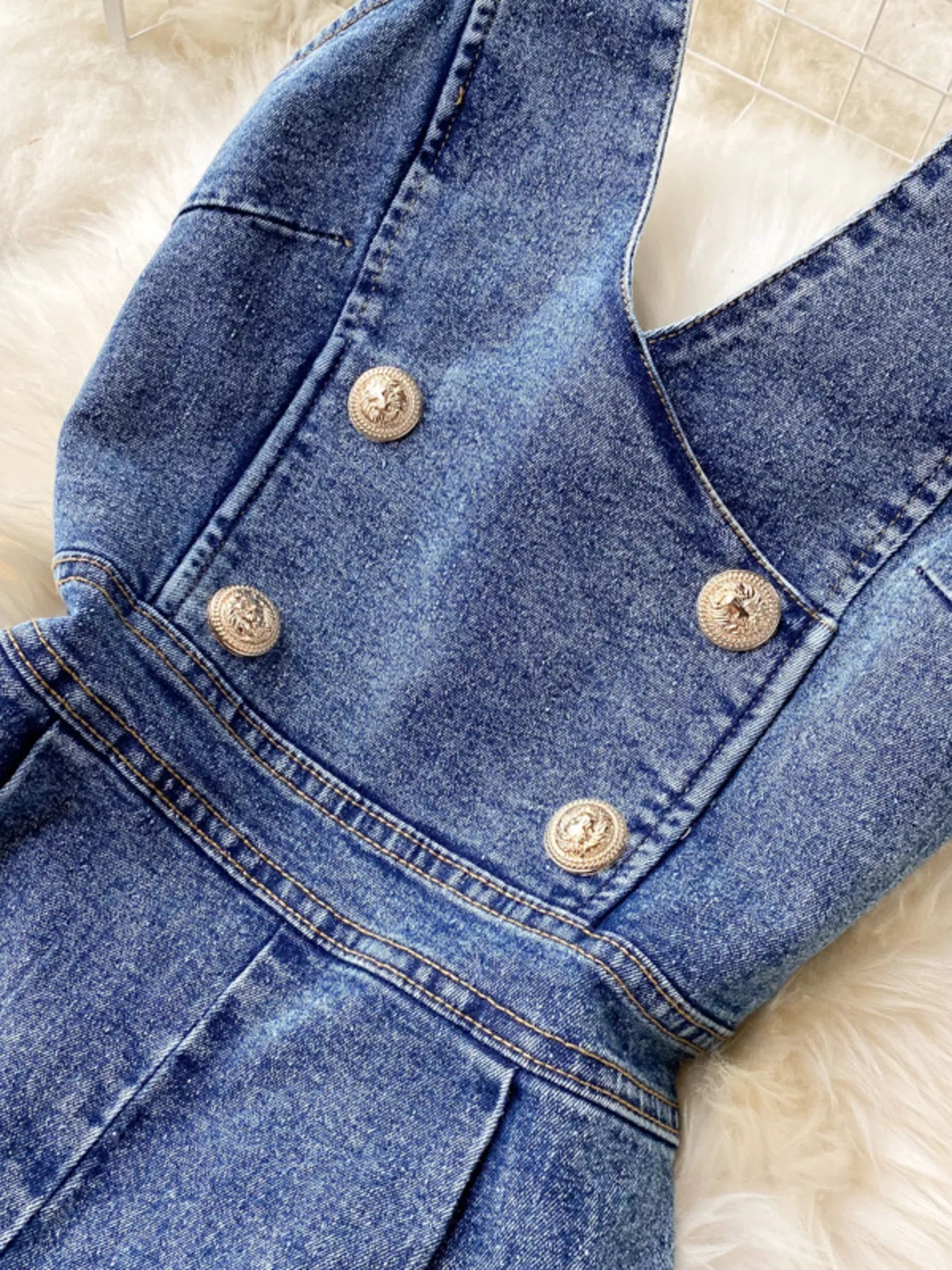 Halter neck wide-leg denim jumpsuit by Trendsi, featuring a fitted bodice and flowing pant legs, displayed on a model.