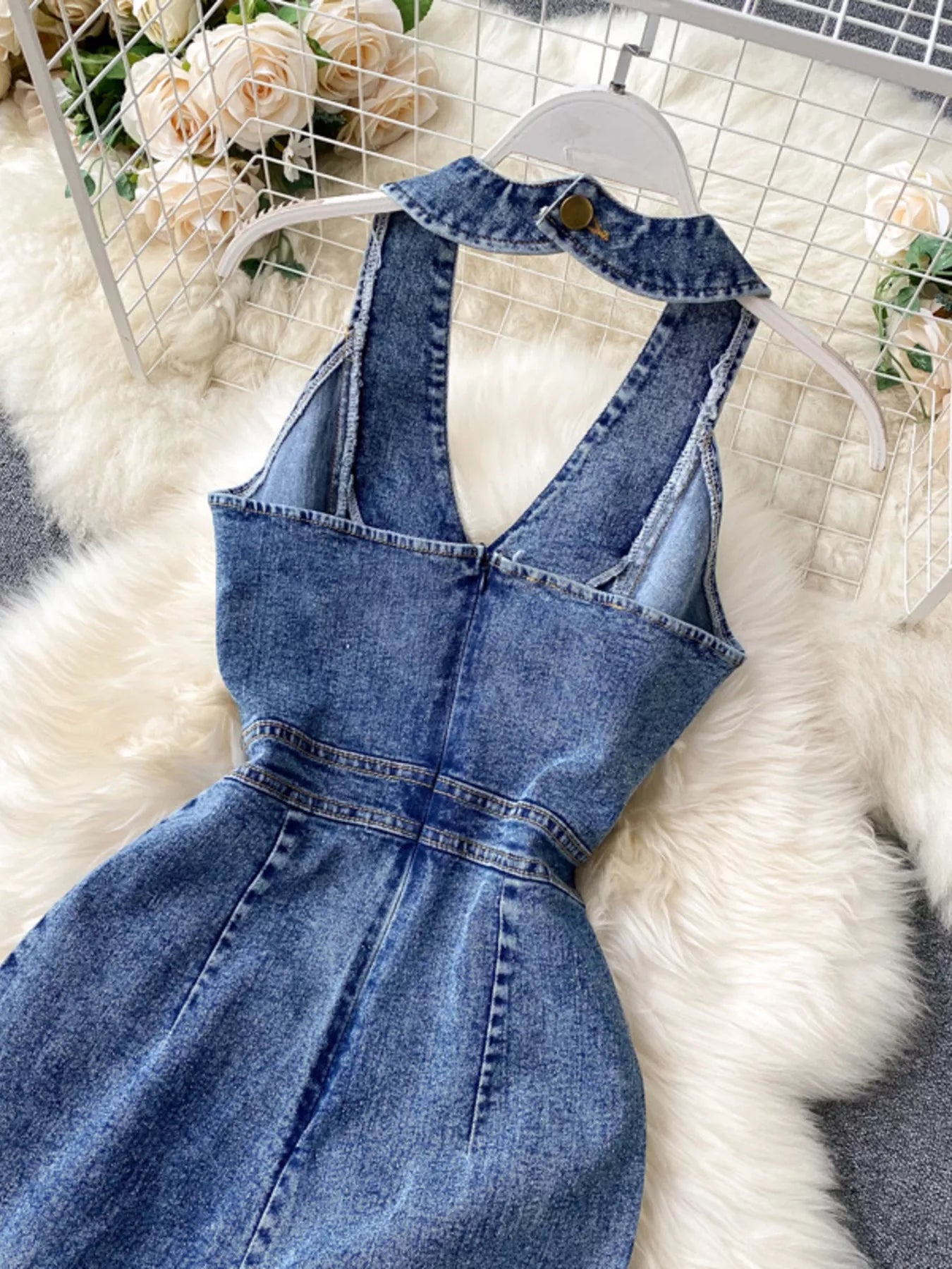 Halter neck wide-leg denim jumpsuit by Trendsi featuring a fitted bodice and relaxed, flared pant legs in classic blue denim