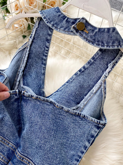 Halter neck wide-leg denim jumpsuit by Trendsi featuring a fitted bodice and flowing pant legs.