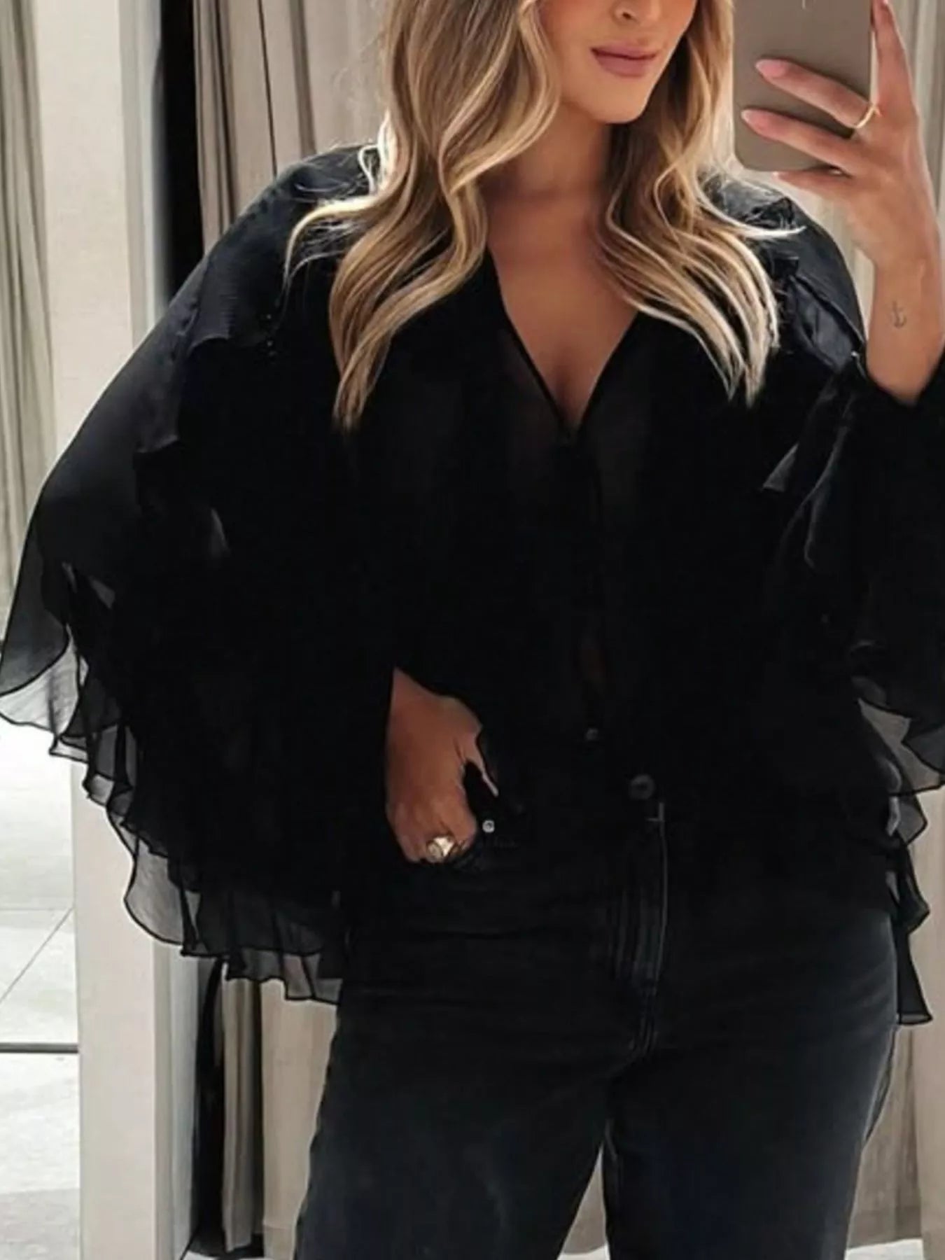 Ruffled sheer long sleeve blouse from Trendsi featuring delicate ruffles and lightweight, transparent fabric for a feminine look.