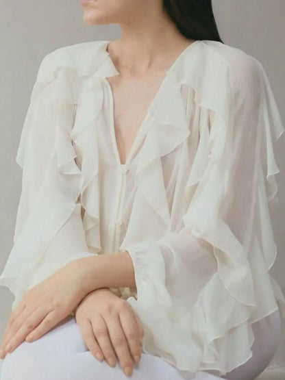 Sheer long sleeve blouse with ruffled details, stylish and flowy, featuring a feminine design perfect for trendy fashion looks.