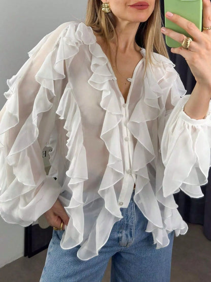Sheer long sleeve blouse with ruffled details from Trendsi, featuring a lightweight, elegant design perfect for stylish outfits.