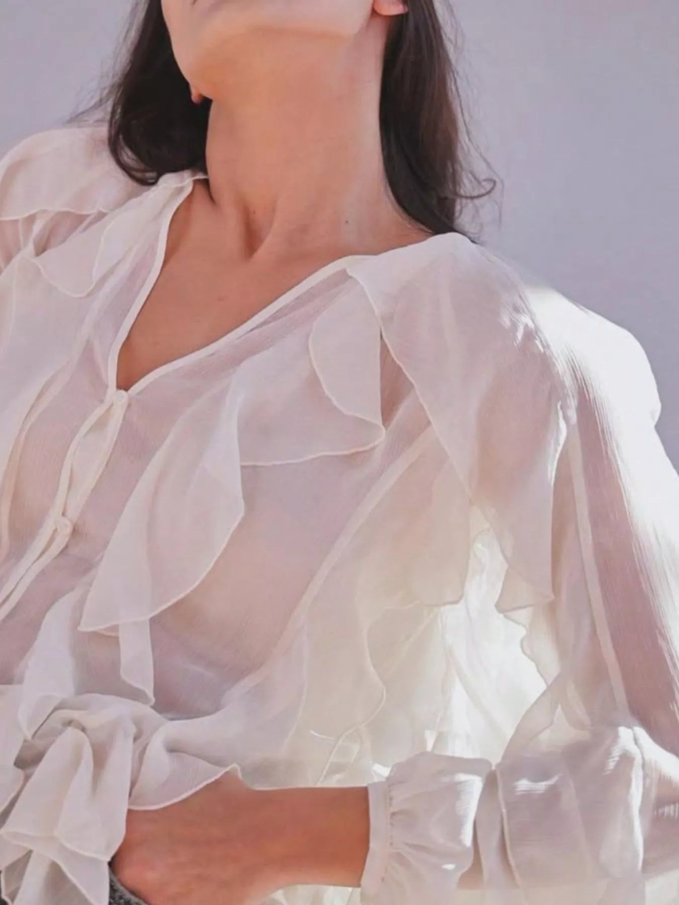Sheer long sleeve blouse with ruffled details from Trendsi, featuring a delicate, elegant design and lightweight fabric.