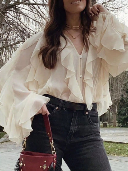 Brown ruffled sheer long sleeve blouse from Trendsi, featuring delicate ruffle details and lightweight, transparent fabric.