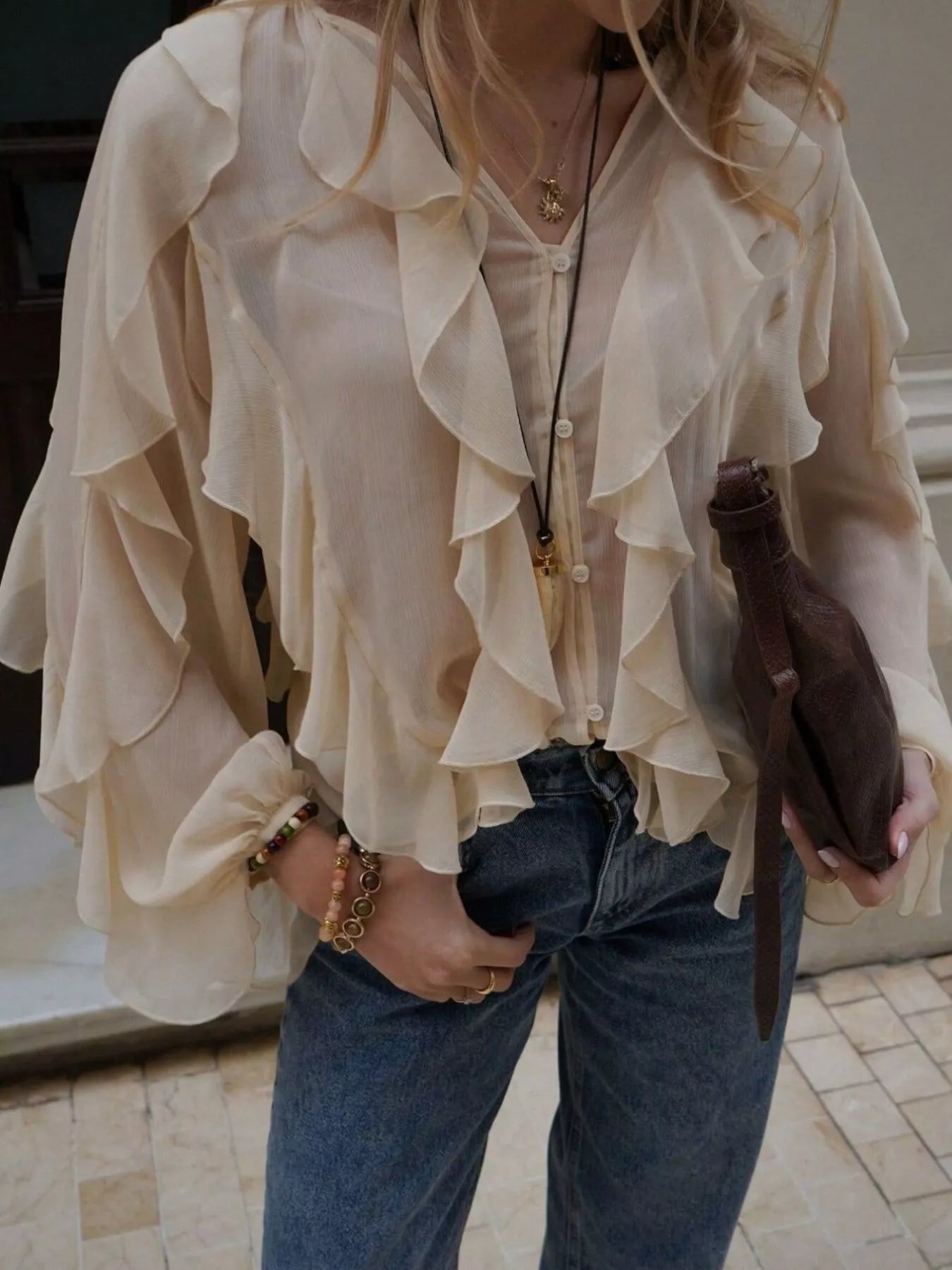 Brown ruffled sheer long sleeve blouse from Trendsi, featuring delicate ruffle details and lightweight, transparent fabric.