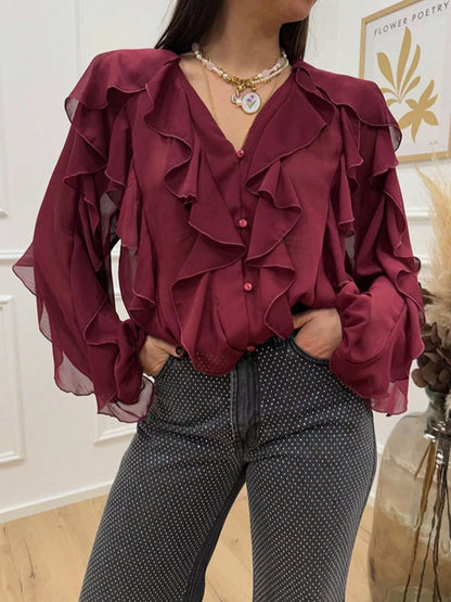 Sheer long sleeve blouse with ruffled accents, featuring a feminine design from Trendsi, shown in a soft, lightweight fabric.