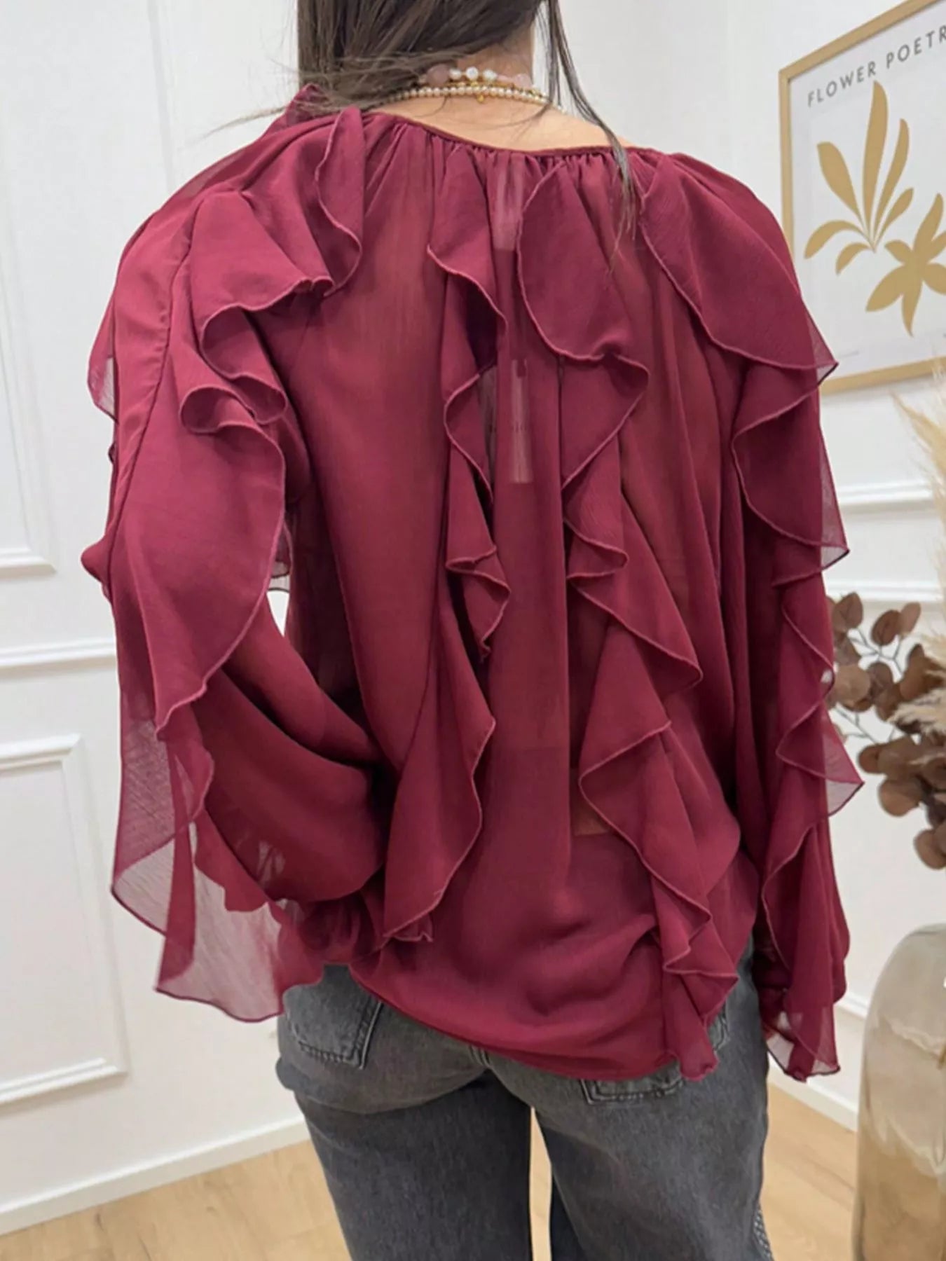 Ruffled sheer long sleeve blouse by Trendsi featuring delicate ruffle details and lightweight, transparent fabric.