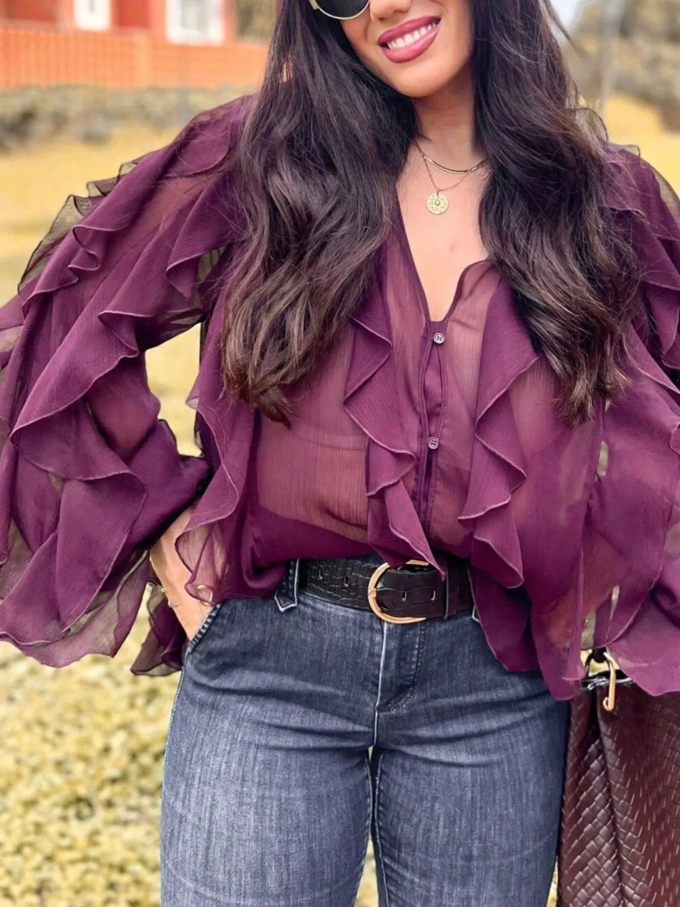 Ruffled sheer long sleeve blouse by Trendsi featuring delicate ruffles and lightweight fabric, perfect for elegant casual wear.