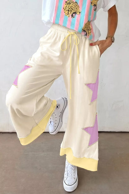 Cream wide-leg pants with star patch design from Trendsi, featuring a relaxed fit and stylish casual look.