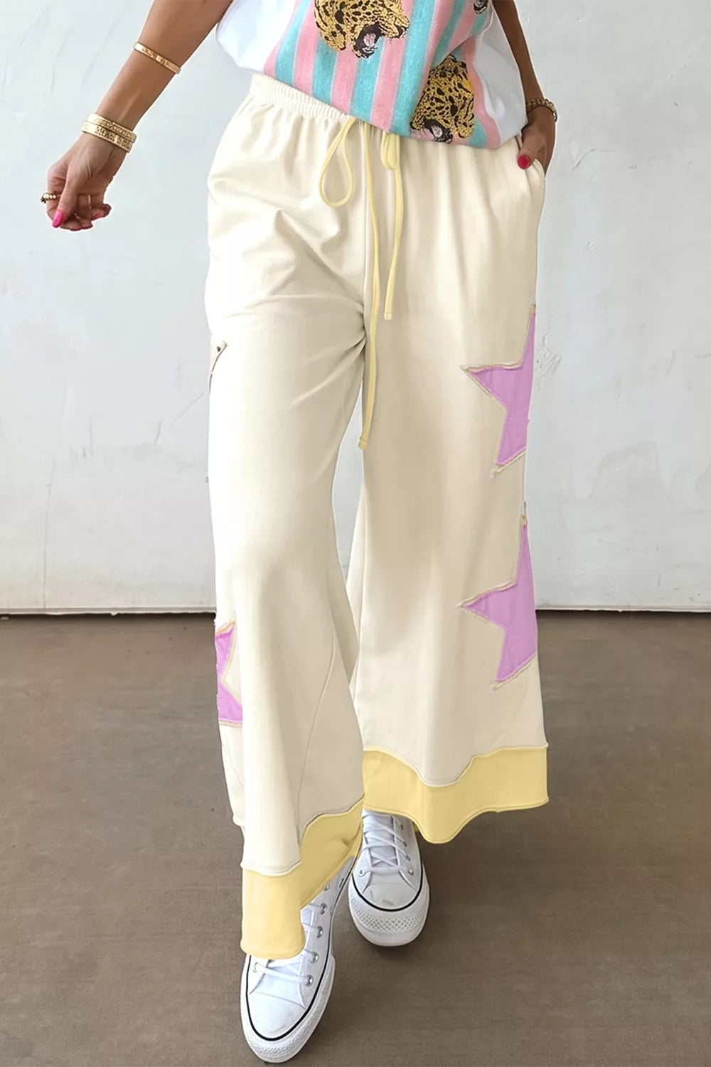 Cream star patch wide-leg pants from Trendsi, featuring a relaxed fit and stylish star details on the fabric.