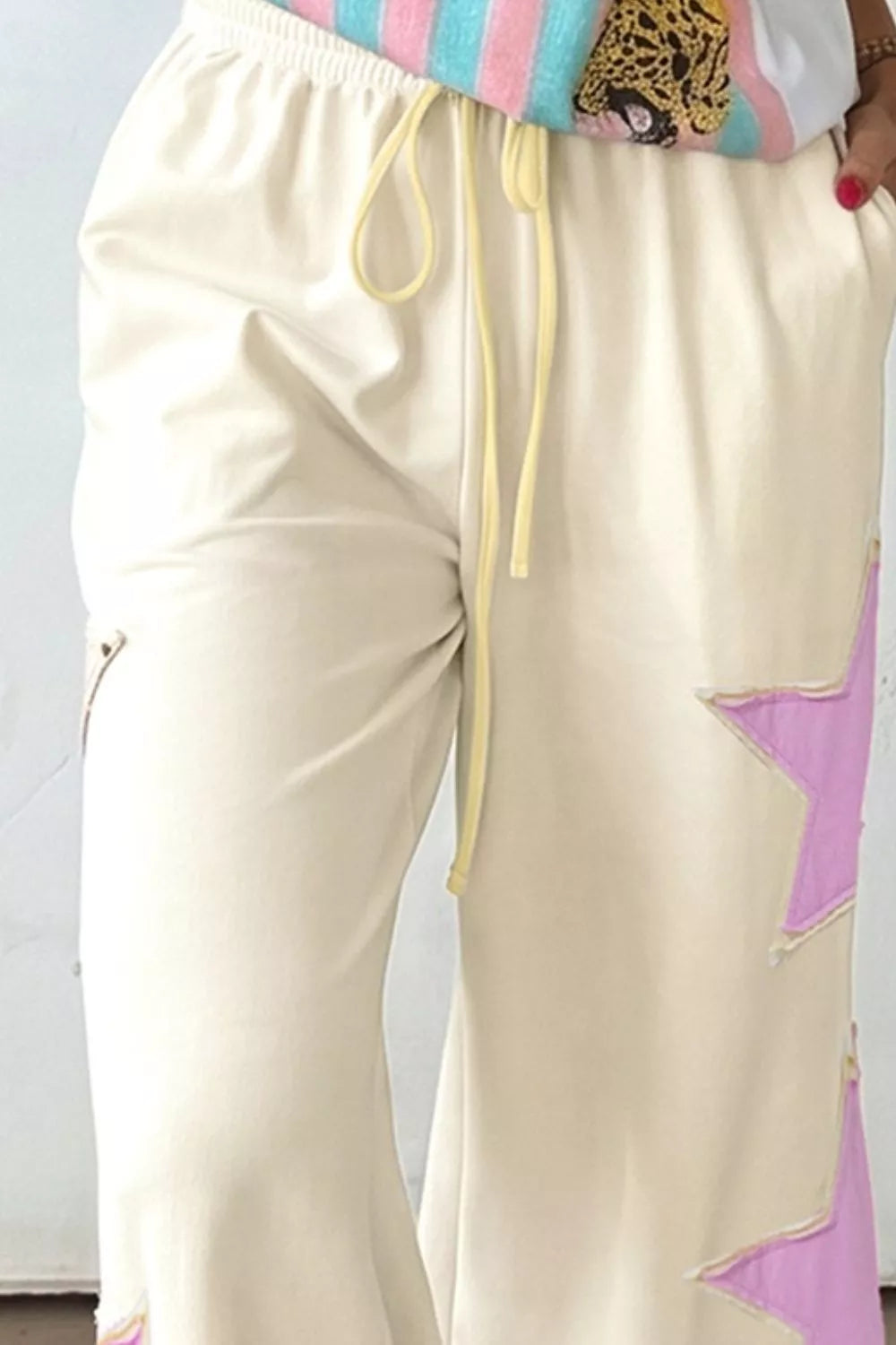 Cream wide-leg pants with star patch details from Trendsi, featuring a relaxed fit and stylish design.
