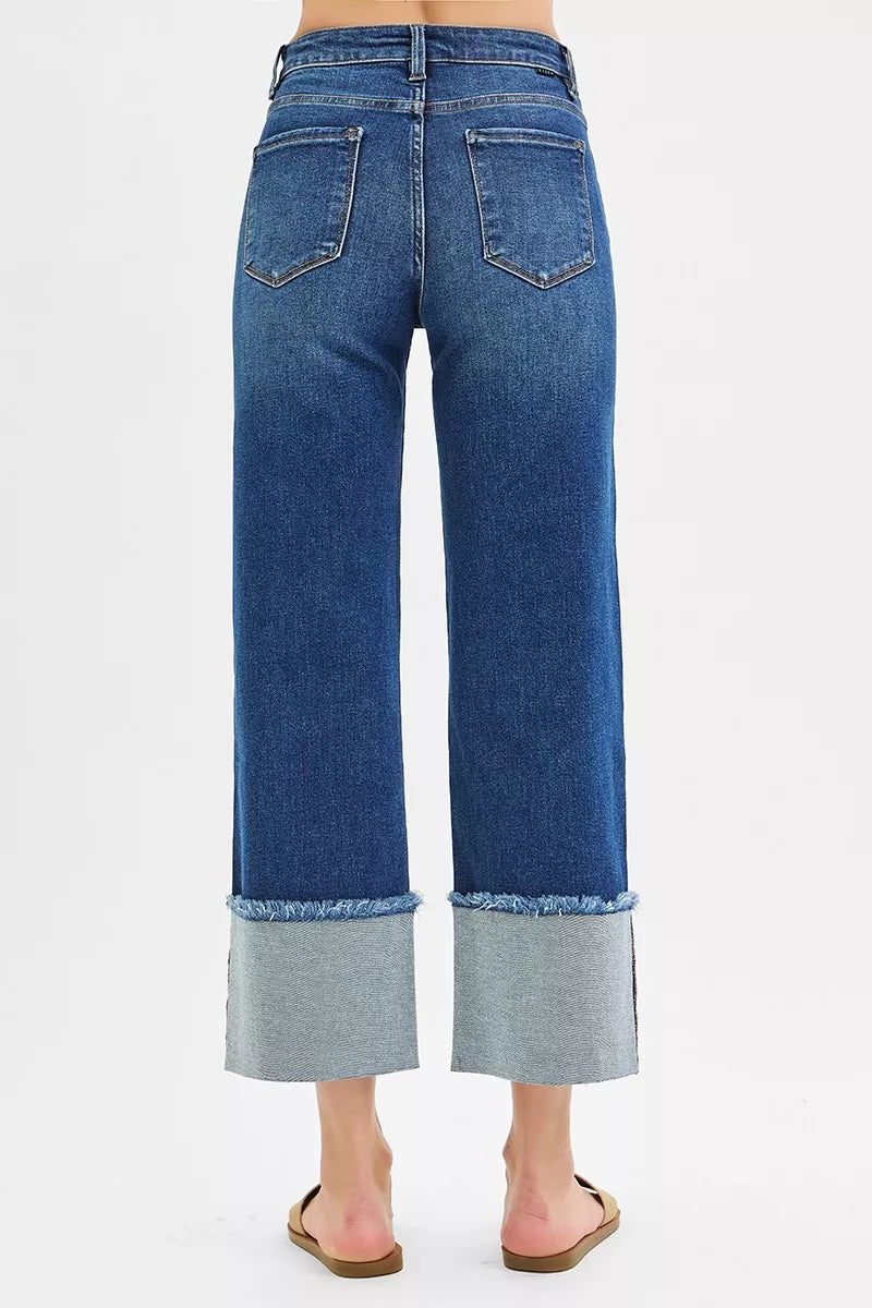 Plus size dark wash Risen mid-rise crop wide cuff jeans from Trendsi, showcasing relaxed fit and stylish wide cuffs.