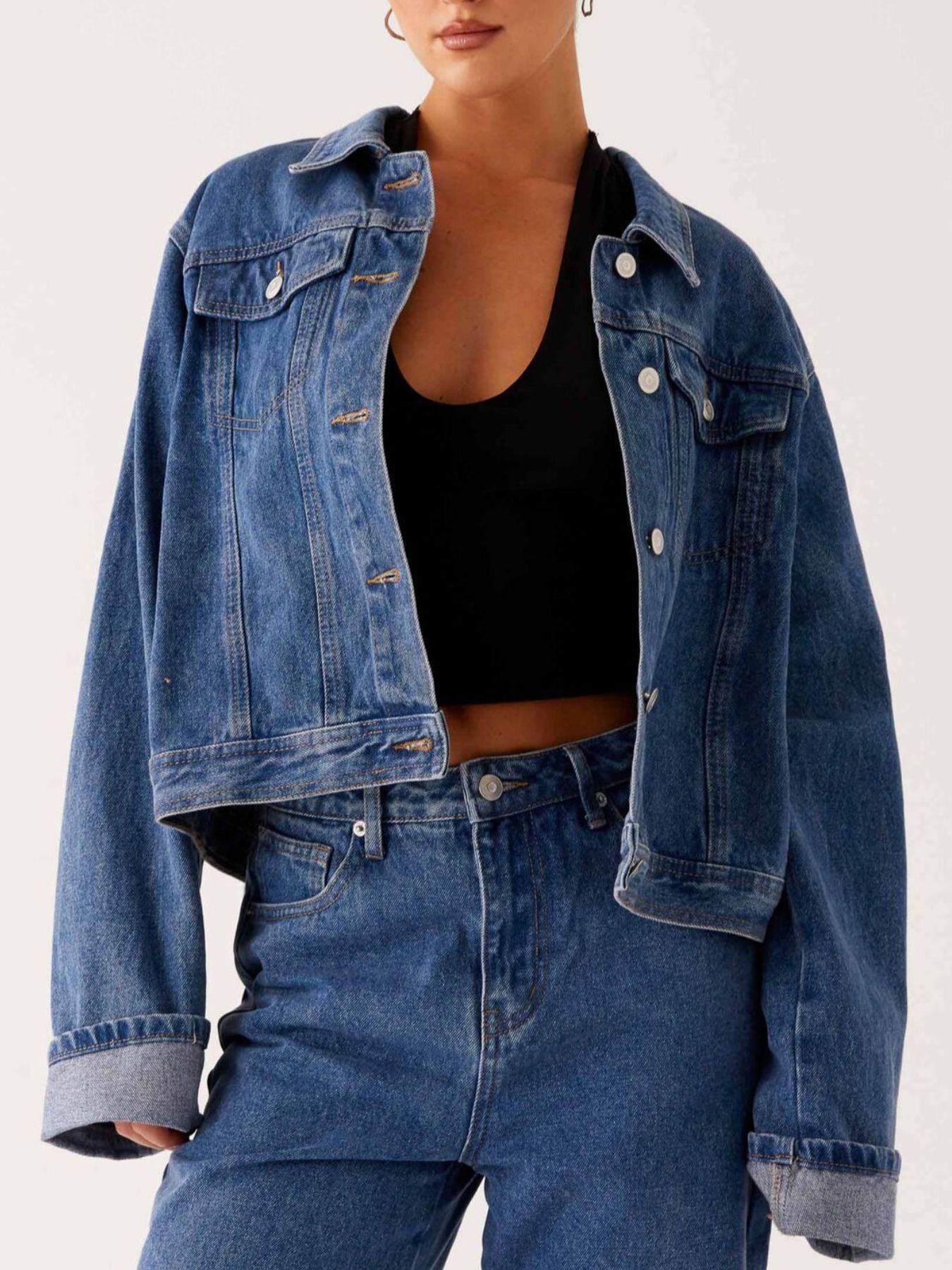 Dark blue oversized denim jacket with button-down front, cropped fit, from Trendsi, displayed on a hanger.